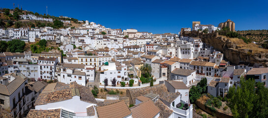 Panoramic view of the beautiful white village of Setenil de las Bodegas since lookout in Cadiz, Spain, with the church and castle in a sunny day. © JoseLuis