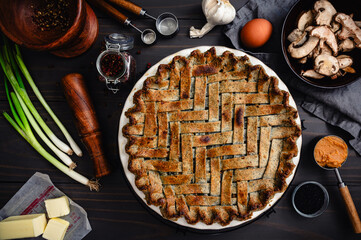 Black Sesame Chicken Pot Pie with Herringbone Lattice Crust: Directly above a baked savory pie surrounded with ingredients and kitchen tools