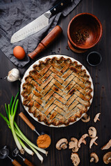 Black Sesame Chicken Pot Pie with Herringbone Lattice Crust: Directly above a baked savory pie surrounded with ingreidents and kitchen tools