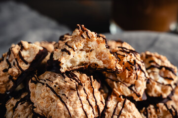 Close-up of a Pile of Macaroons Drizzled in Dark Chocolate: Plate of toasted coconut meringue drop cookies dipped in bittersweet chocolate close-up