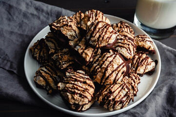 Close-up of a Pile of Macaroons Drizzled in Dark Chocolate: Plate of toasted coconut meringue drop cookies dipped in bittersweet chocolate close-up