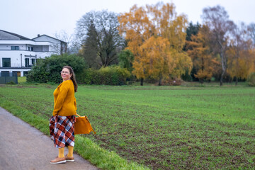 Natural lifestyle portrait joyful woman in glasses enjoying outdoor walk, matching yellow...
