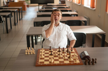 Middle aged Caucasian man playing chess. 