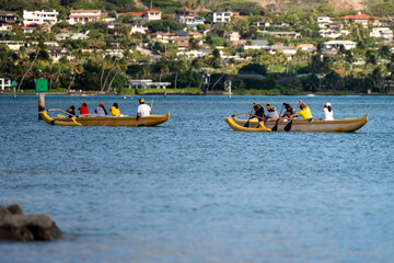 Fototapeta premium Competitive paddlers in 6-person canoe glide in perfect harmony across tranquil waters, their synchronized strokes capturing unity and adventure in a serene outdoor escape.