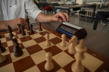 A man switches a chess clock. 