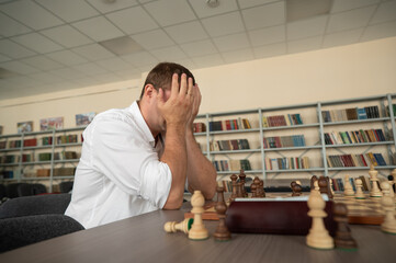 Caucasian man upset after losing chess game. 