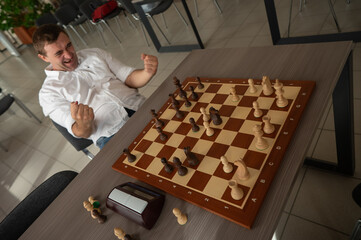 Caucasian man celebrates winning chess. 