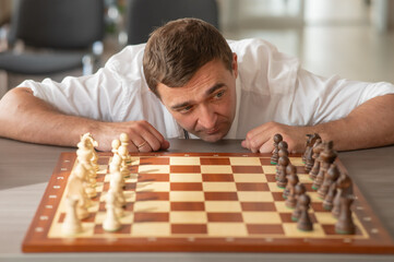 Middle aged Caucasian man playing chess. 