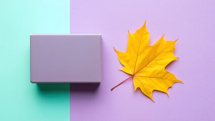 Autumn flat lay with yellow maple leaf and gift box on pastel background top view photo