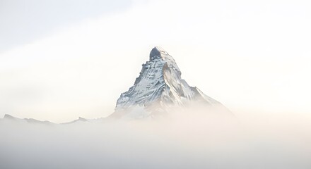 Majestic snow-capped Matterhorn peak emerges from a misty, ethereal landscape.