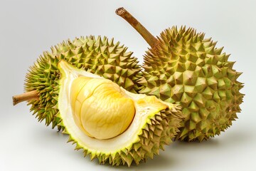 Obraz premium Fresh durian fruit with spiky shell and yellow flesh on a clean background.