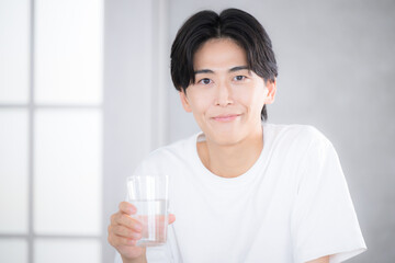 朝に水を飲む男性　水分補給などのクローズアップ