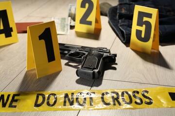 Forensic expertise. Crime scene with evidence, markers and police tape on floor, closeup
