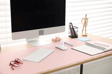 Stylish workplace with wooden desk, stationery and computer at home office, closeup