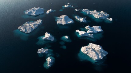 Aerial view of scattered icebergs floating in dark, calm ocean water under natural light.