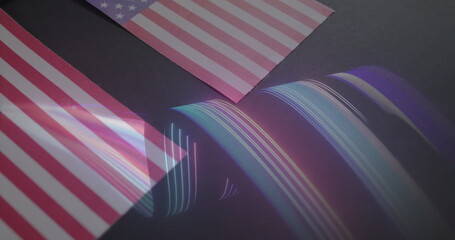 Projecting curved rainbow waves sweeping across studio desk, with prism and American flag cards
