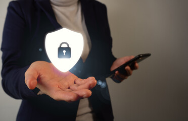 Online security concept, businesswoman's hand holding a virtual icon of a shield with a closed...