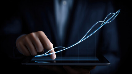 Business professional analyzing growth data on a digital tablet in a dark environment