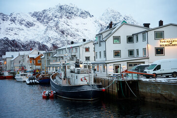 The picturesque Snowy Harbor features charming boats surrounded by stunning scenic mountains