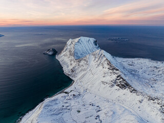 A Majestic SnowCapped Mountain Range Overlooking the Beautiful Ocean at Sunset Time