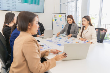 Group of Asian businessmen are analyzing charts and graphs during productive meeting, demonstrating...