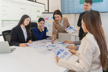 Group of Asian businessmen are analyzing charts and graphs during productive meeting, demonstrating...