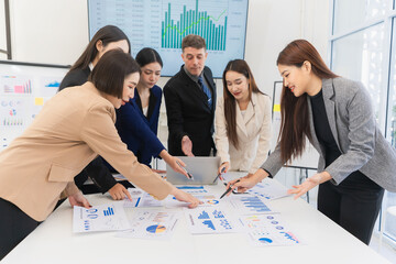 Group of Asian businessmen are analyzing charts and graphs during productive meeting, demonstrating...