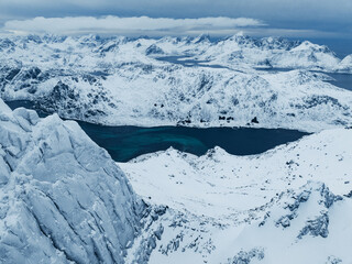 Enjoy the stunning aerial view of snowcapped mountains and a beautiful glacier lake