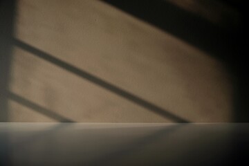 Empty room with sunlight and shadow from window on wall and floor. Beige studio background for product presentation.