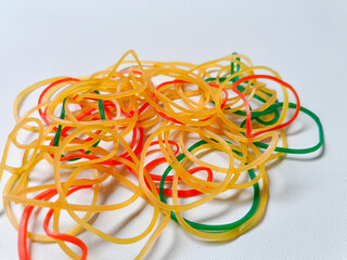 A collection of brown, red, and green rubber bands isolated on a white background.