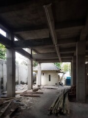 Defocused of a Partially built concrete structure with scattered materials near a small tiled-roof...