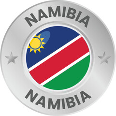 Namibia flag in silver colored medal. National flag in metal circle emblem.