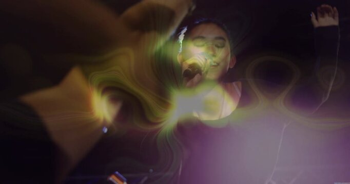 Female singer raising microphone singing under stage lights with neon overlay energizing crowd