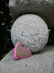 Historic stone ball with I love you heart shaped rock vertical photo