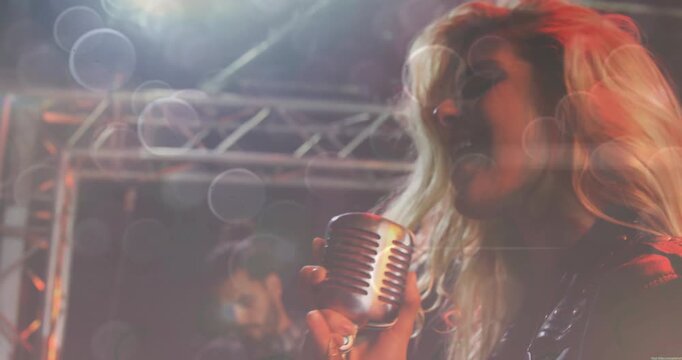 Singer stepping on stage gripping vintage mic and singing verse under warm spotlights for band show