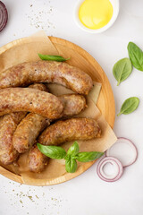 Plate of tasty homemade sausages on grey background