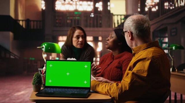 Colleagues practicing script reading in a public library with mockup, engaged in drama rehearsal and character development. Cast members preparing for classic theatre performance. Camera A.