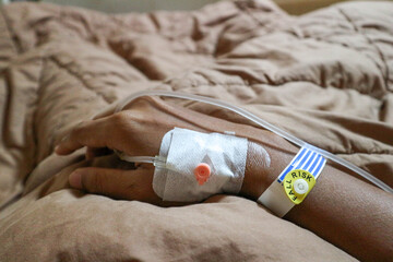IV or intravenous drip in patient hand and warning of fall risk for patient in hospital