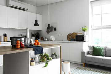 Interior of light kitchen with modern appliances on wooden table