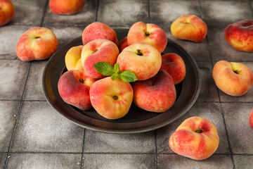 Plate with sweet fig peaches and mint on grey tile table