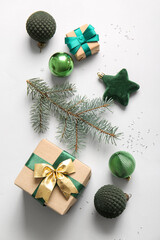 Christmas tree branch with balls and gift boxes on white background
