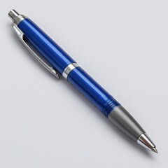 Modern metallic blue ballpoint pen with silver accents and a textured grip isolated on a clean white background