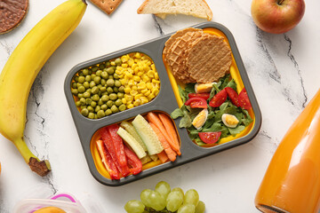 Lunchbox with delicious food and bottle of juice on grunge white background