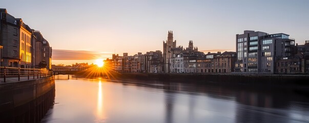 Fototapeta premium City skyline at sunrise over a river.