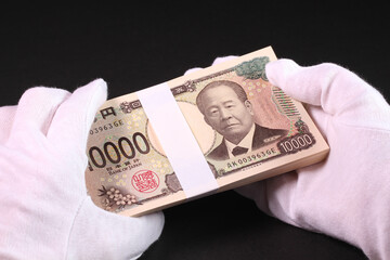 白手袋で札束を持つ