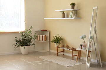 Stylish interior of modern hallway with houseplants and mirror