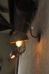 Old-fashioned wall lamp adds warmth to rustic interior