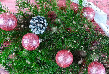 Christmas wreath. Christmas atmospheric mood. New Year decorations. Christmas tree toys hanging on branches,  snowing. Happy New Year. Cozy ambiance at home, holiday spirit.