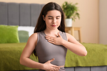 Pretty young woman doing breath practice at home