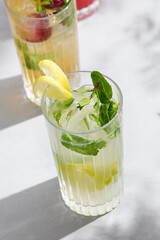 Mojito lemonade, bright sunlight, overhead composition with lemon twist and mint garnish